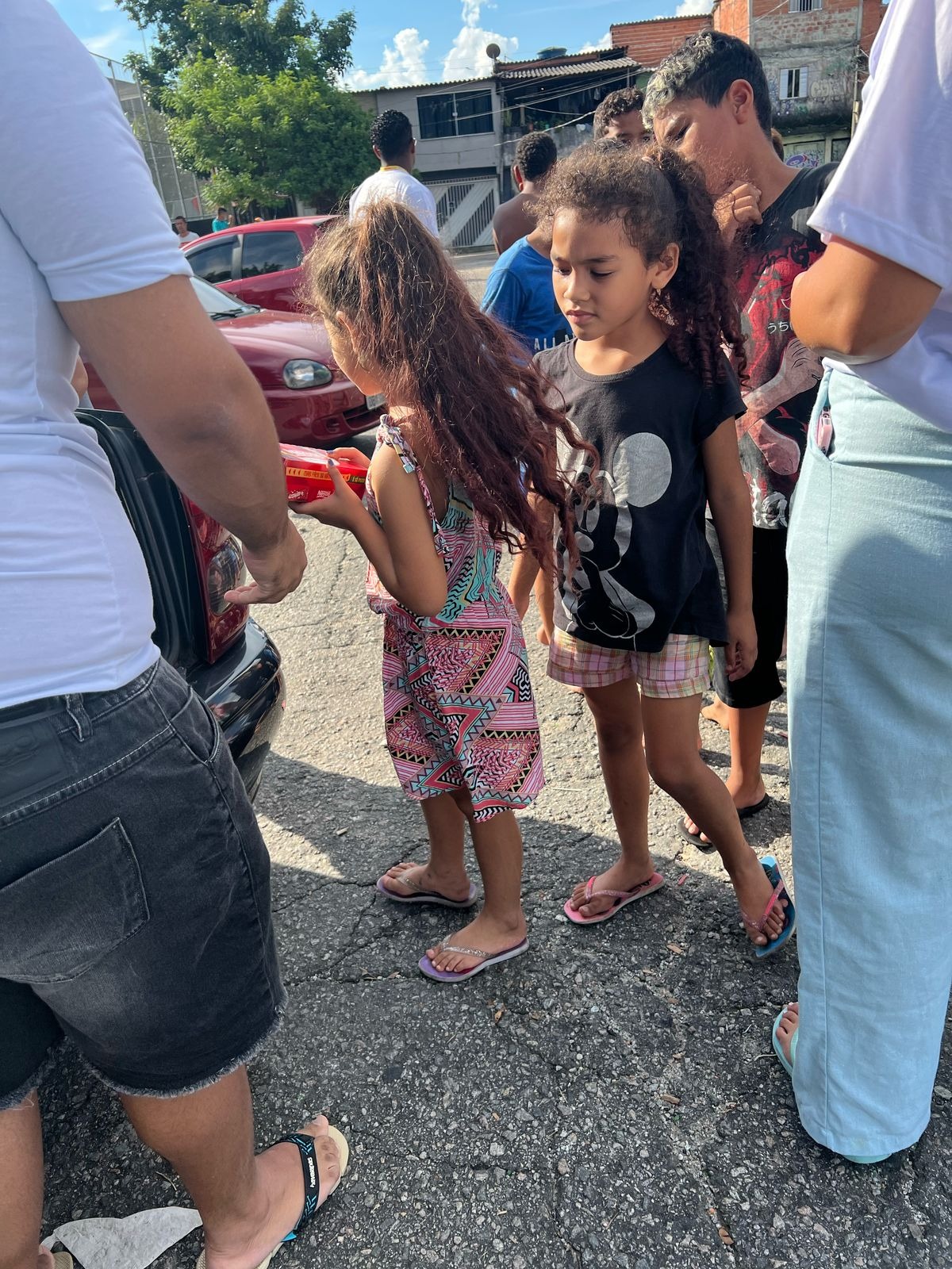Famílias recebendo ovos de páscoa e abraços durante o evento do Instituto Rose Major